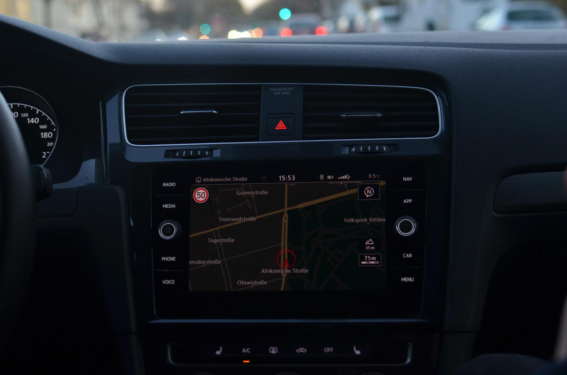 Interior of modern car with steering wheel and navigation system showing route through city streets