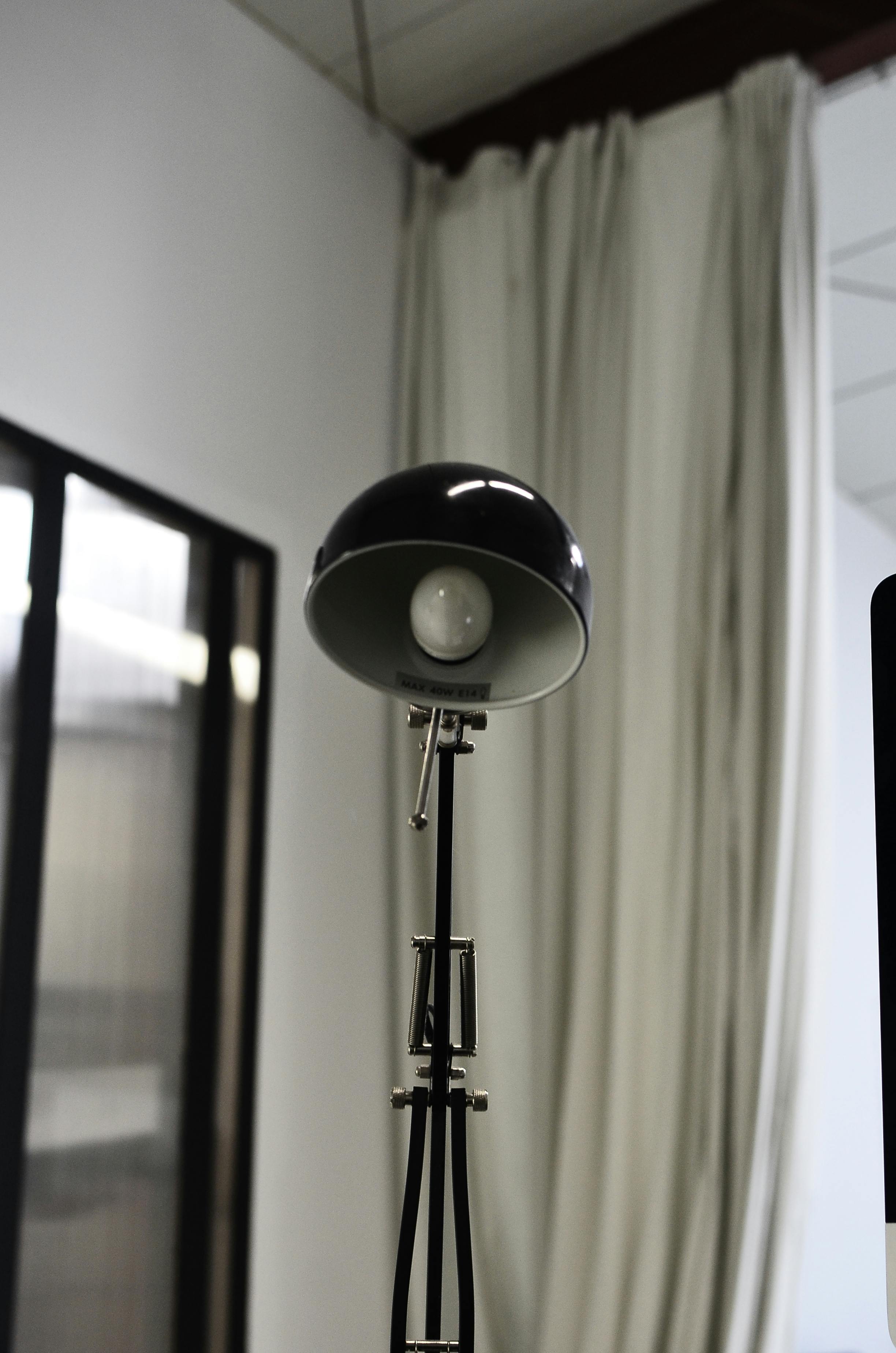 Elegant metal lamp in a modern office setting, showcasing minimalist interior design.