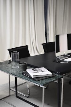 Sleek and stylish modern office conference room with chairs, table, and a computer screen.