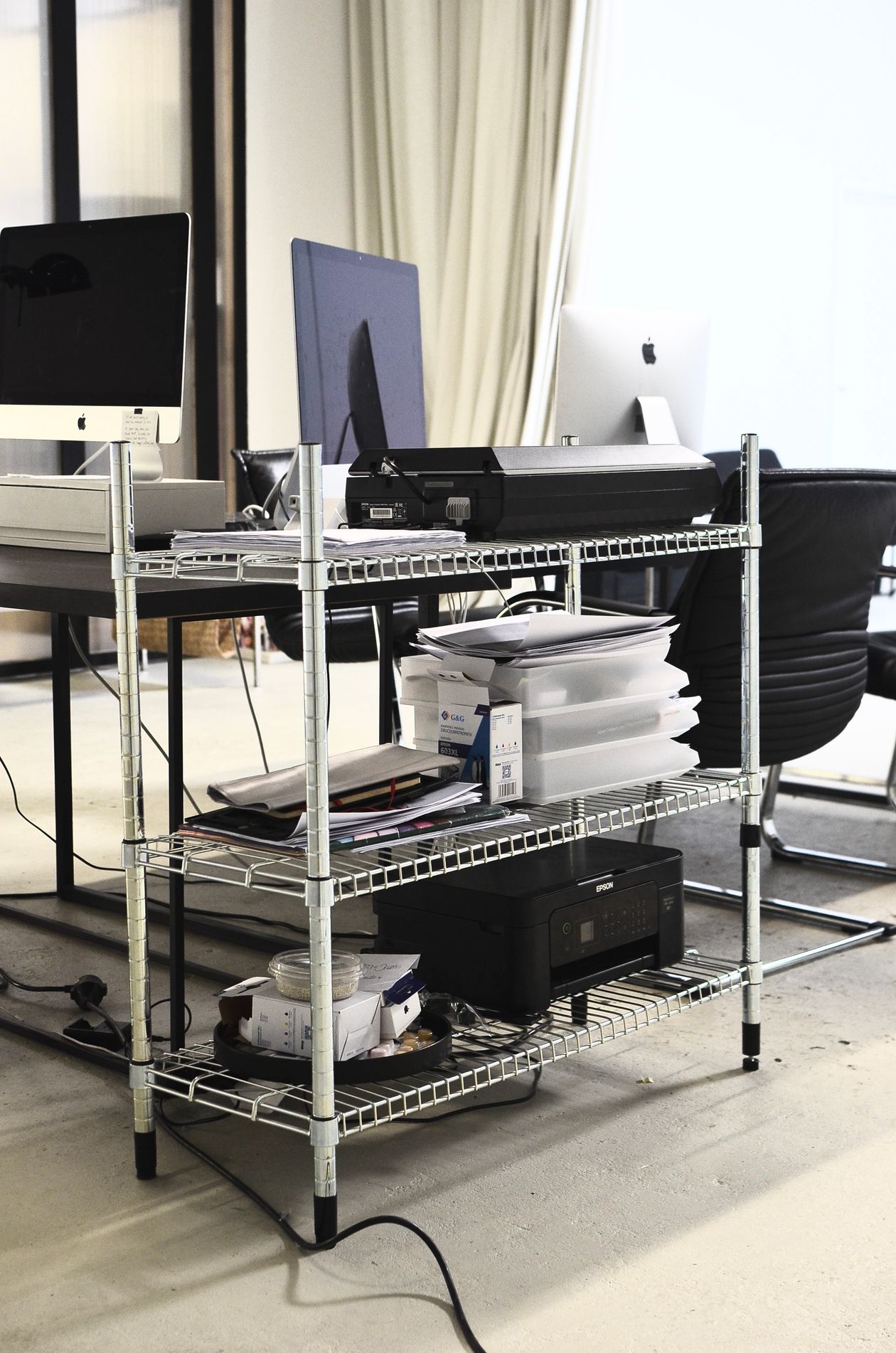 chrome wire shelf holding office equipment and papers