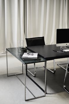 A stylish and contemporary workspace with a modern desk, chair, and computer setup, perfect for creative professionals.