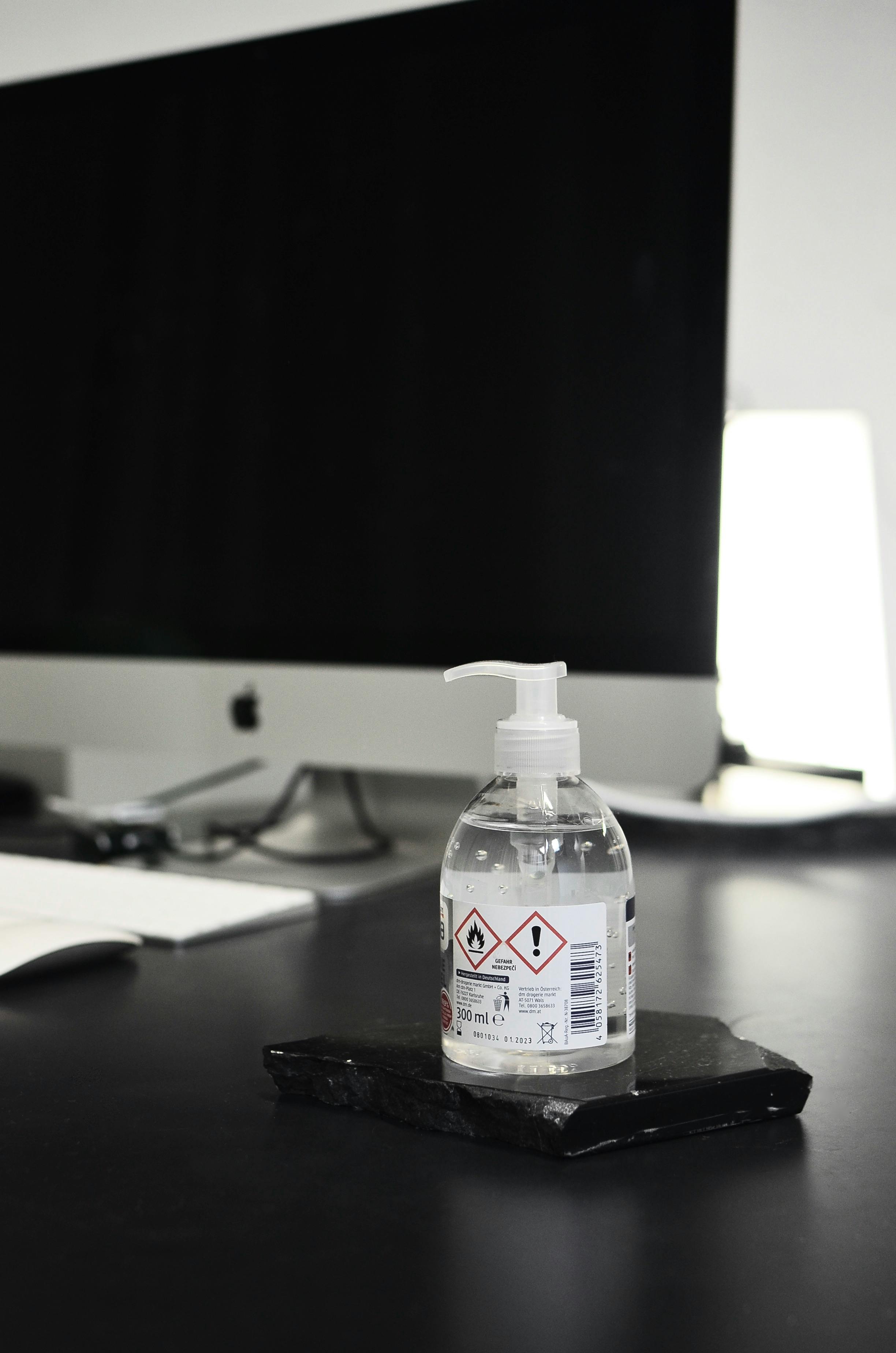 antibacterial hand gel placed on table against modern computer