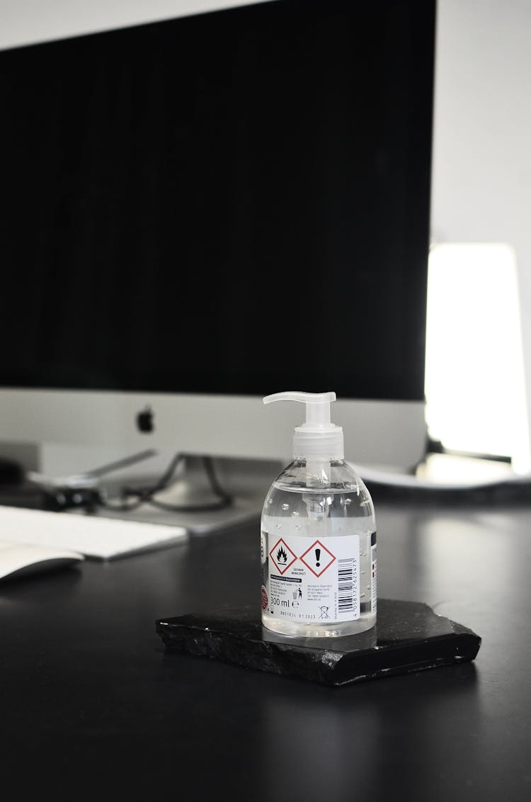 Antibacterial Hand Gel Placed On Table Against Modern Computer