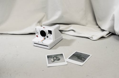 Instant photos placed near modern instant photo camera