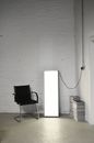Armchair near floor lamp in empty house