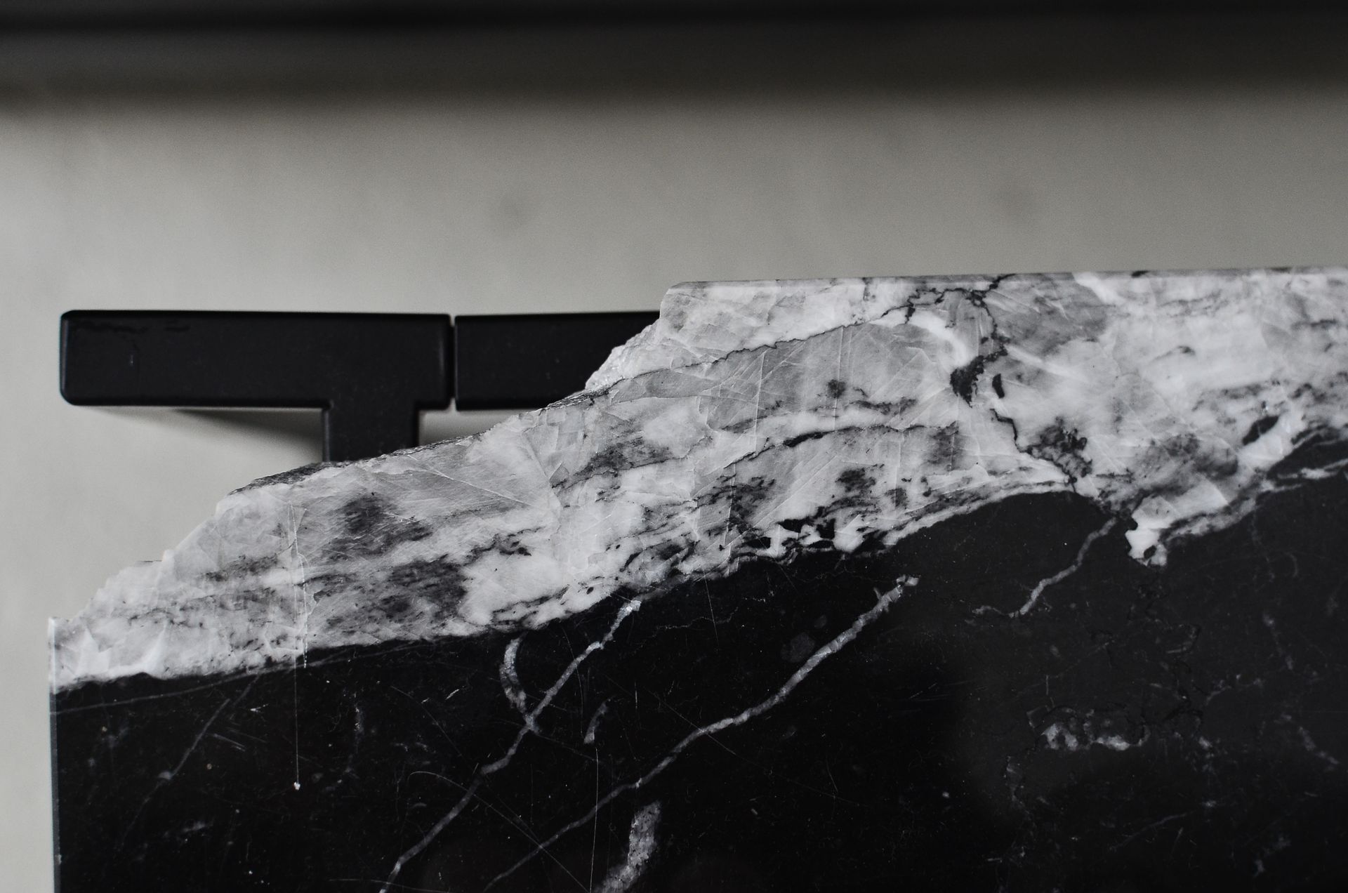 Top view of aged table with damaged marble surface on floor in house room in daylight