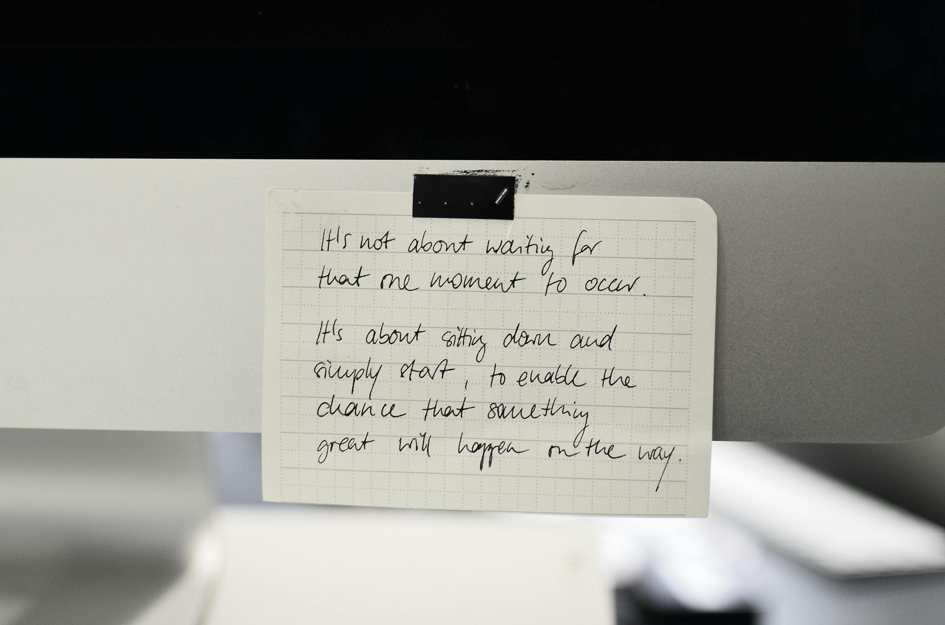 Written text with black words on rectangular shaped paper sheet with square ornament in daylight