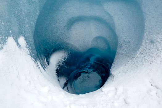 A mesmerizing view of a natural ice formation in a glacier with vibrant blue hues.