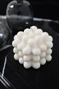 Black and white from above unusual white candle of creative geometrical shape placed on dark table in modern living room