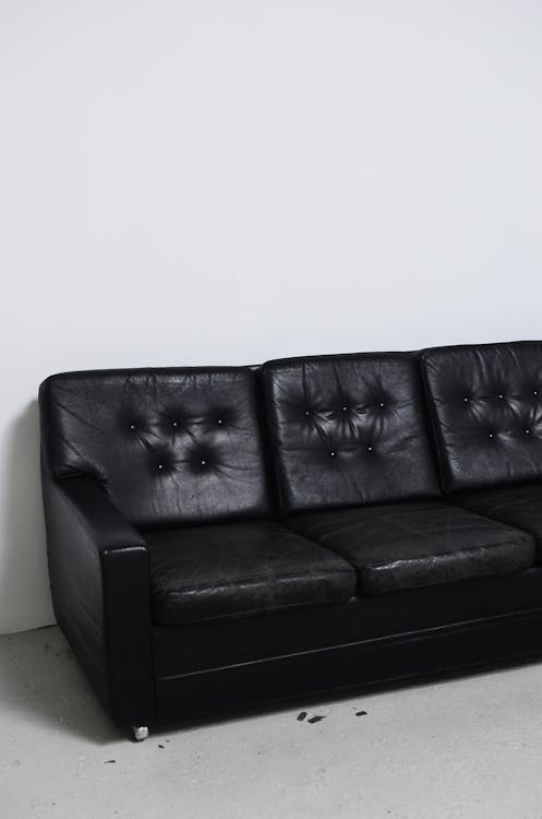 Weathered black leather sofa in light room