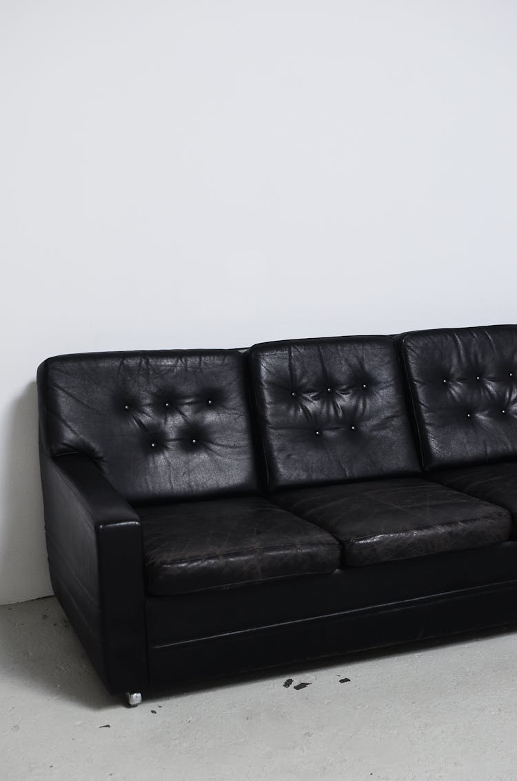 Weathered Black Leather Sofa In Light Room