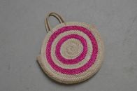 From above of colorful straw bag with beige handles on gray shabby surface