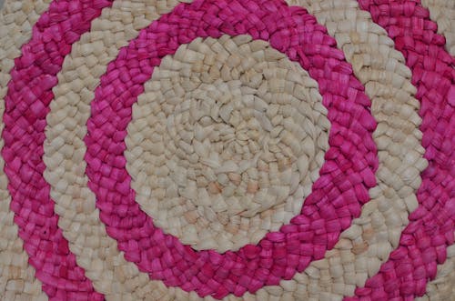 Top view of stylish multicolored bag with various circles from straw on floor
