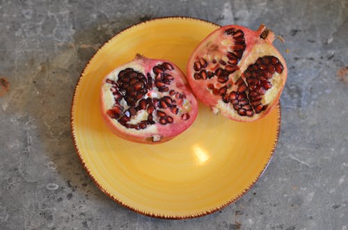 Fresh pomegranate on yellow ceramic plate