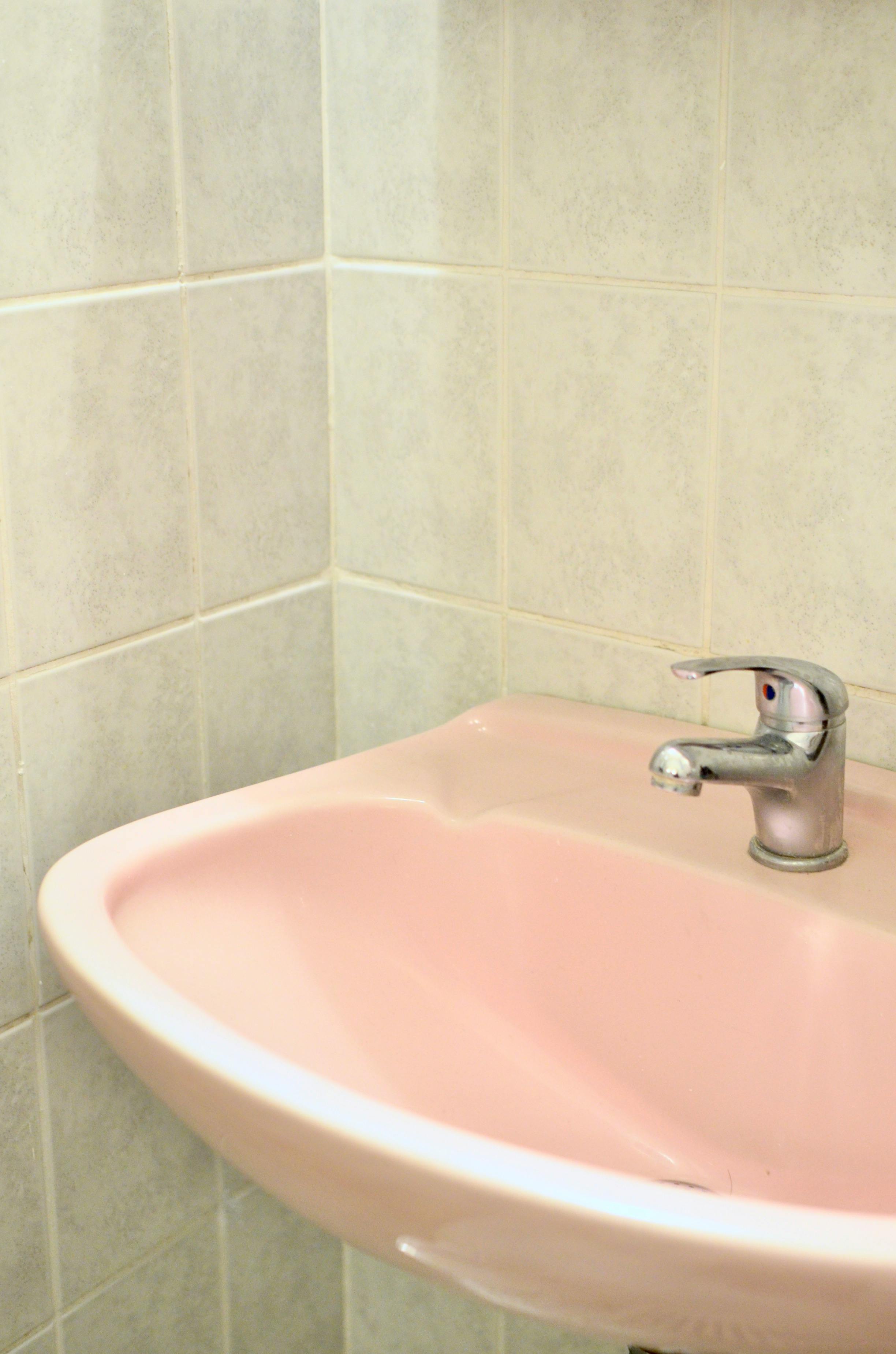 pink sink in bathroom near wall