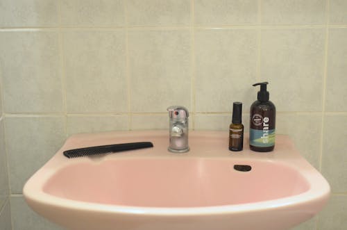 Sink with skincare products in bathroom
