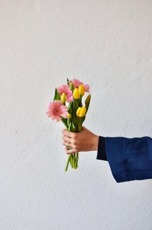 Free Crop person with bouquet of flowers Stock Photo