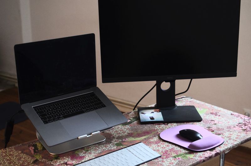 monitor mounted on articulating arm above a standing desk