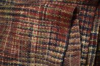 Folded boucle fabric knitted or woven of uneven yarn with a surface of loops and curls