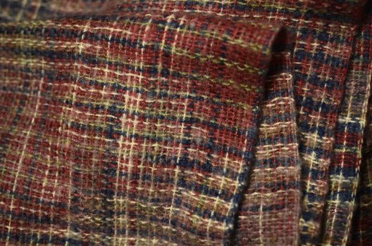 Folded boucle fabric knitted or woven of uneven yarn with a surface of loops and curls