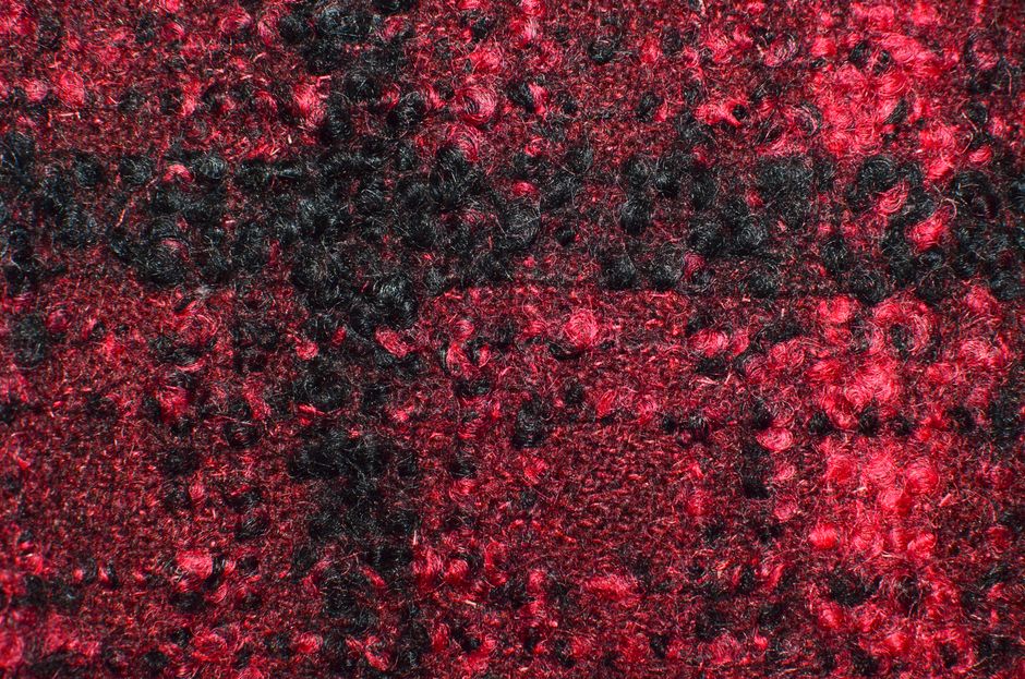Full frame textured background of soft red and black colored fabric for carpet