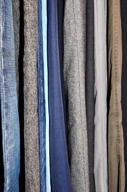Free Stack of various stylish cloth of new collection with different fabric texture and diverse color hanging in modern dressing room Stock Photo