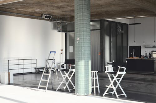 Interior of modern studio with chairs and kitchen furniture