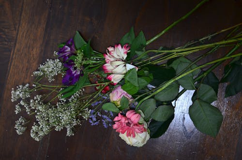 бесплатная Розовые и белые цветы на коричневом деревянном столе Стоковое фото
