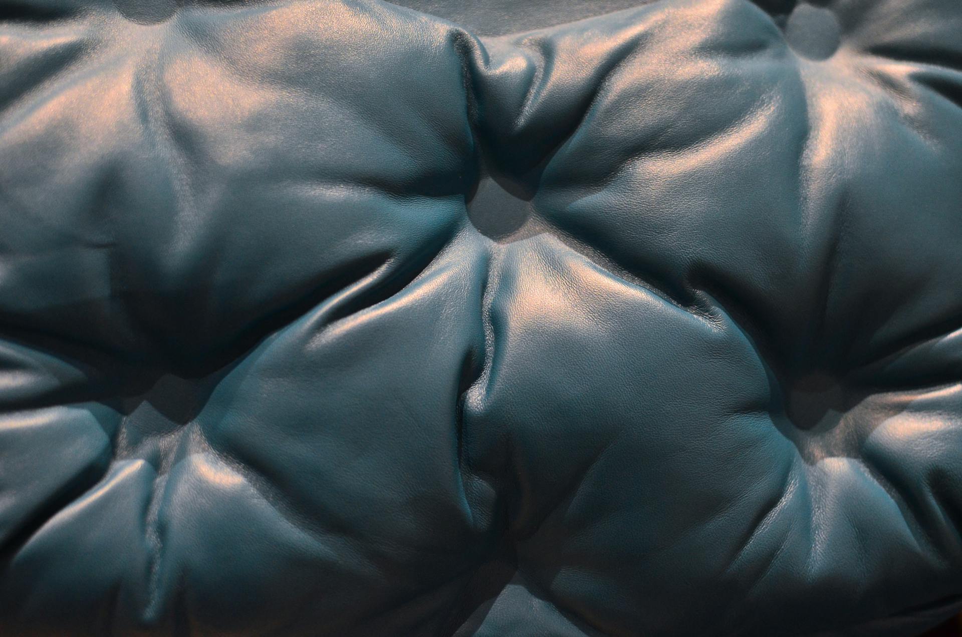 Close-up of luxurious blue leather upholstery with intricate texture and elegant design.