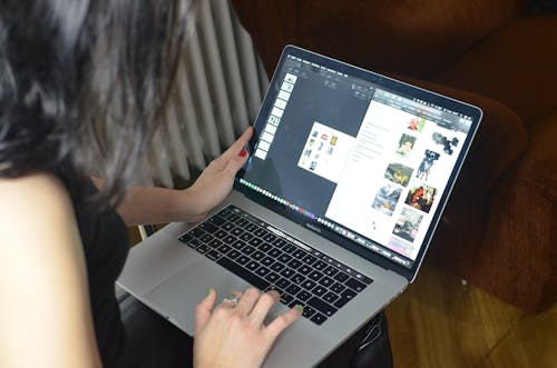 茶色の木製テーブルでmacbook Proを使用している女性