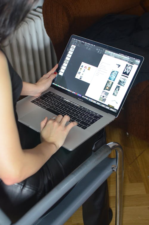 Orang Yang Menggunakan Macbook Pro Di Kursi Kulit Hitam