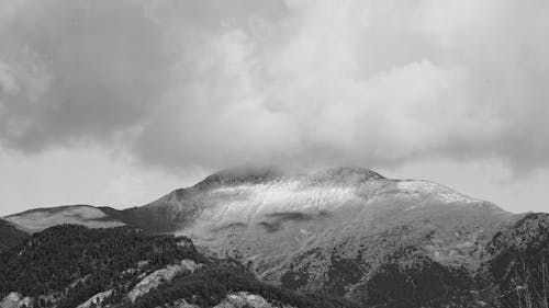 Free Grayscale Photo of a Mountain Under a Cloudy Sky Stock Photo
