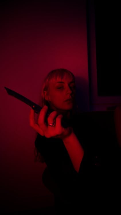 Free Woman with knife in dark room Stock Photo