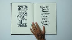 Unrecognizable woman with opened sketchbook with inscription and drawing