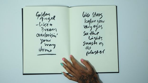 Crop woman with opened notebook with inscriptions