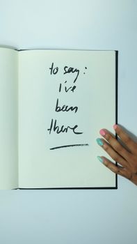 Unrecognizable informal woman with sketchbook with inscription