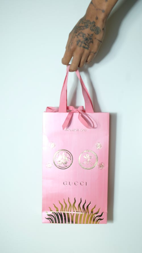 Crop woman carrying pink shopping bag