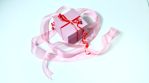 Present box decorated with red band and ribbon