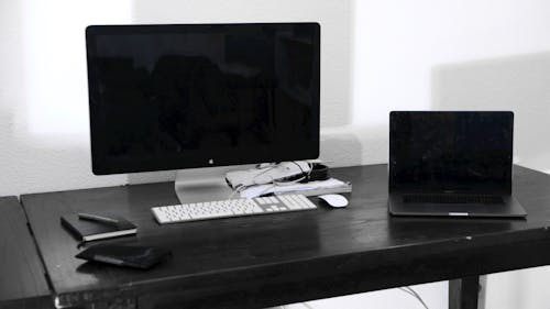Modern computer and laptop on table in room