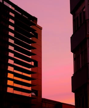 Silhouette of buildings against a stunning pink sunset sky in Pontevedra, Spain.