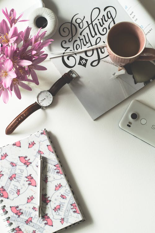 Free Brown Mug Near Watch and Flower on White Surface Stock Photo