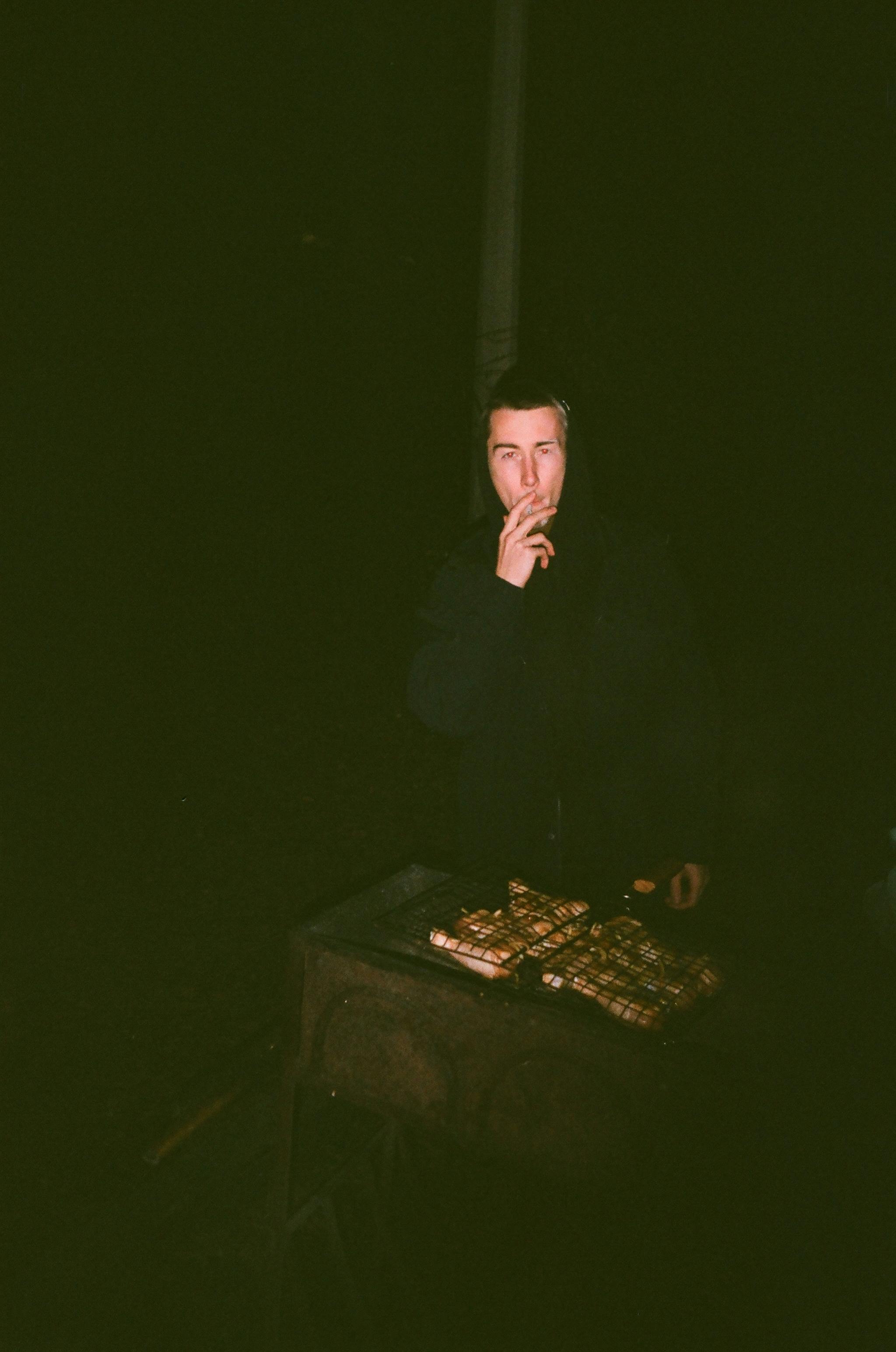 man in black long sleeve shirt smoking cigarette