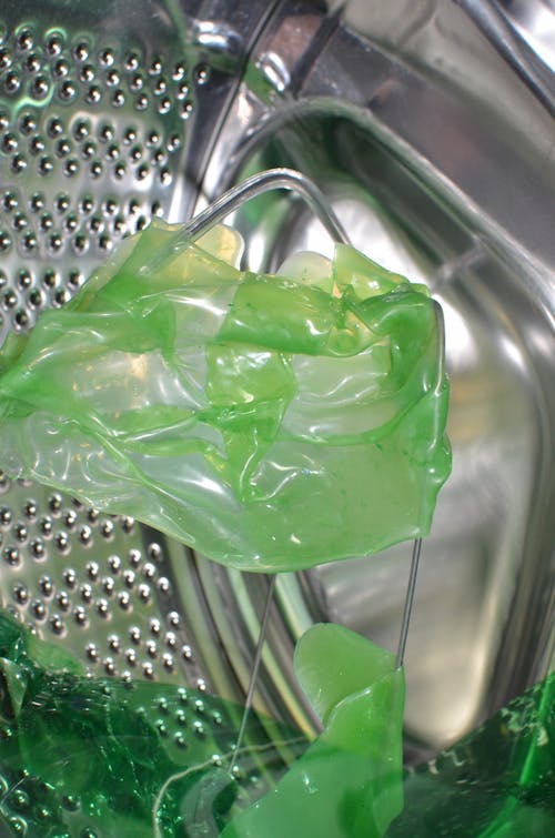 Зеленый пластиковый контейнер на раковине из нержавеющей стали