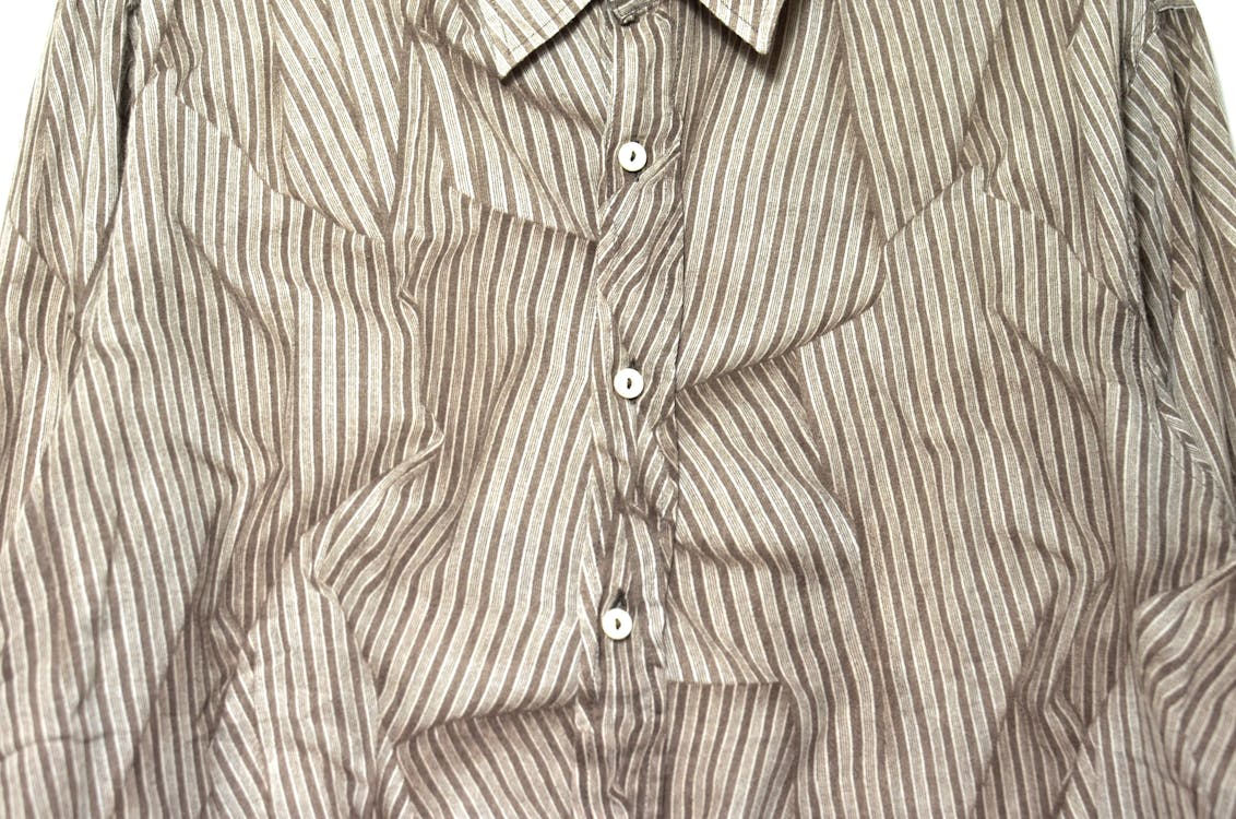 From above full frame of creased classy shirt with vertical gray stripes fastened with white buttons