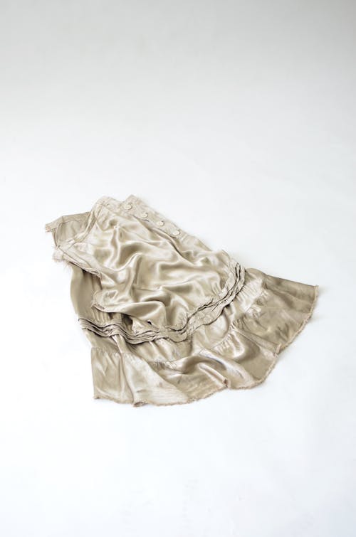 Crumpled elegant gray silk skirt on white surface
