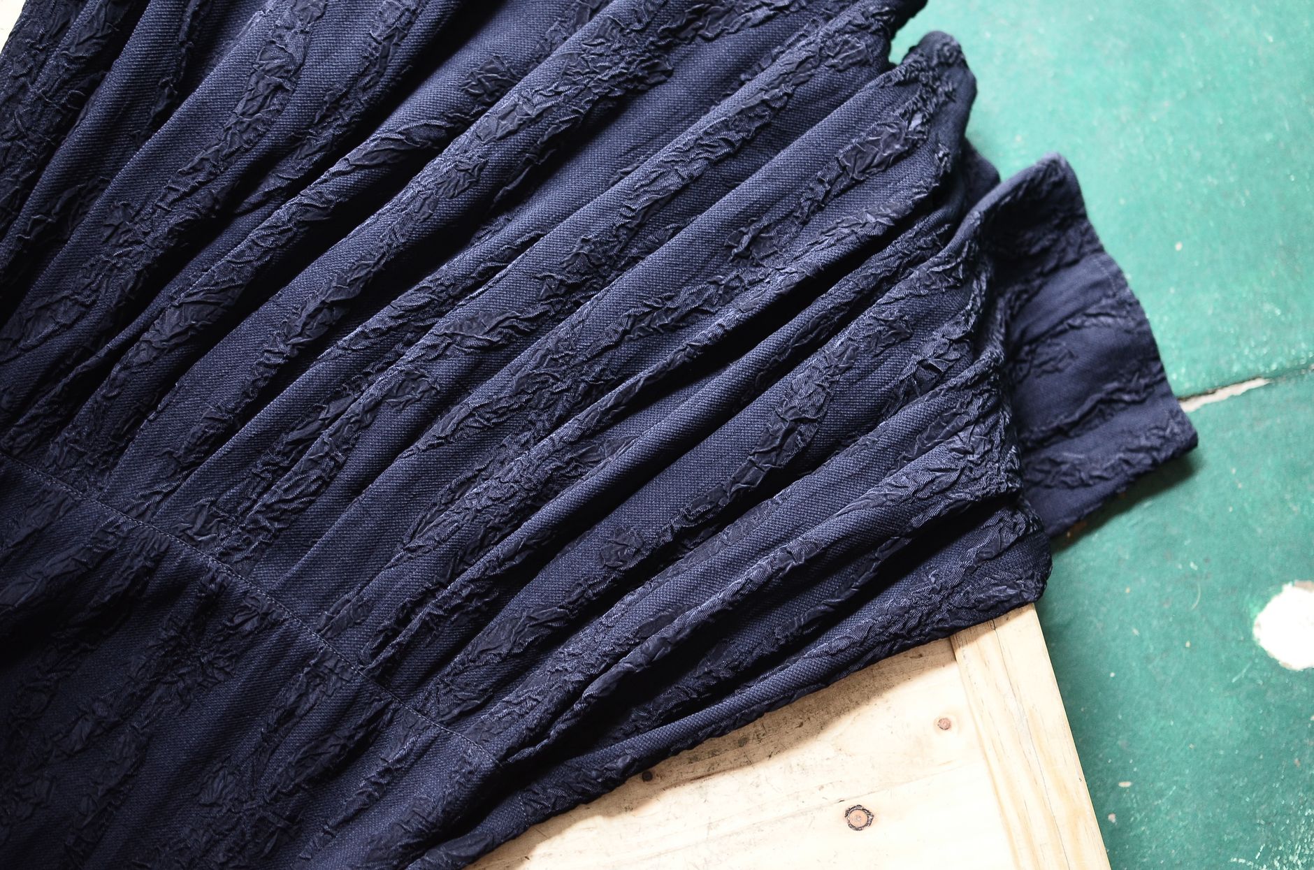 A close-up of a garment showing poor construction quality — the type of signal that reads as junior rather than senior