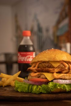 Tasty cheeseburger served with golden fries and refreshing soda in a cozy setting.