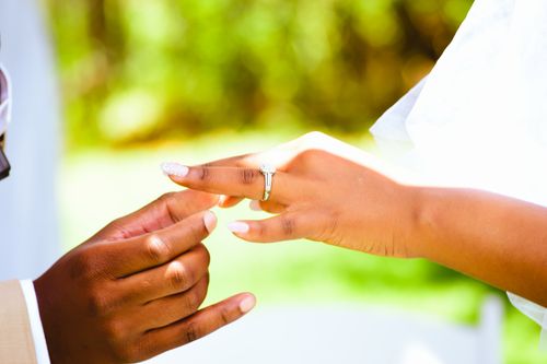 Free Close-up image capturing a wedding ring being placed on a bride's finger, symbolizing commitment and love. Stock Photo