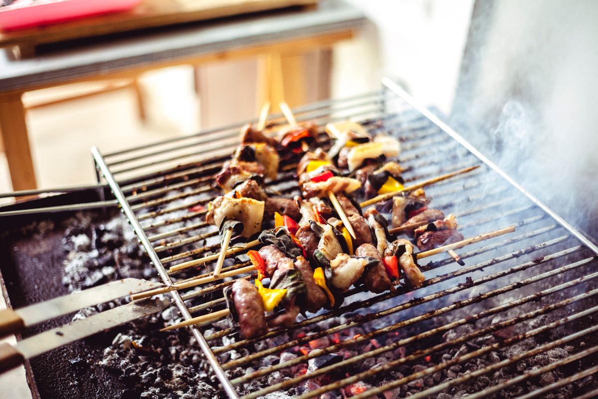 Close-up of grilled food on skewers with charred marks and seasonings
