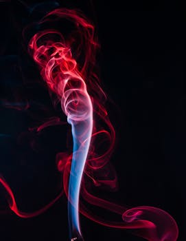 在黑暗背景下，令人着迷的抽象艺术展示了充满活力的红色和蓝色旋转烟雾